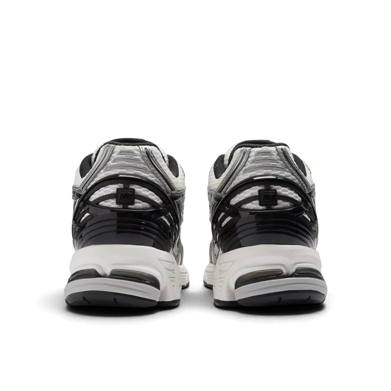 Vue arrière des baskets We Have It New Balance 1906R en mesh argenté et noir avec renforts au talon